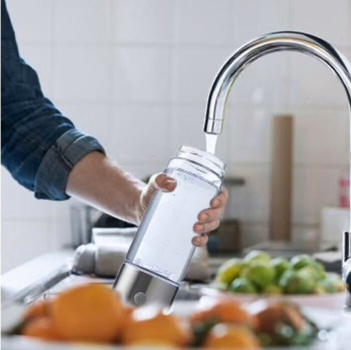 Aquivor Flasche wird am Wasserhahn befüllt